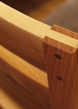 Stühle aus Nussholz wurden passend zu den Tischplatten gefertigt. Dabei wurden auf Details wie starke Schlitz und Zapfenverbindungen und echte Holznägel geachtet