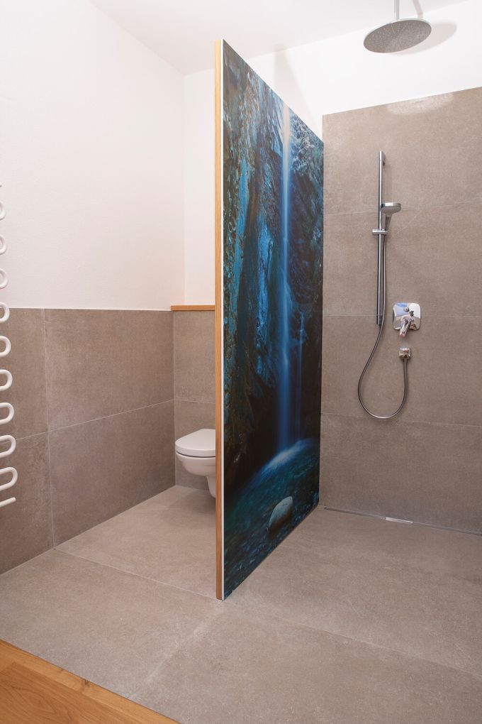 Ein Badezimmer mit Blick auf eine Duschtrennwand mit Wasserfallmotiv