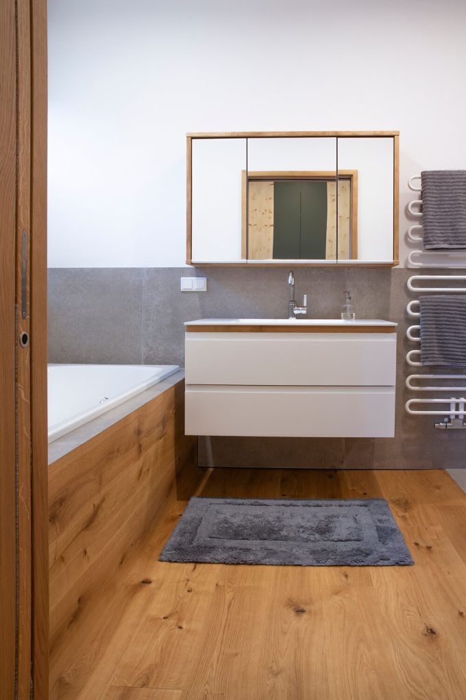 Ein Badezimmer in Eiche mit Blick auf einen Waschtisch und Spiegelschrank