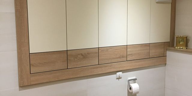 Ein Badezimmer mit Blick auf einen bündigen Wandverbau mit Holzdekor