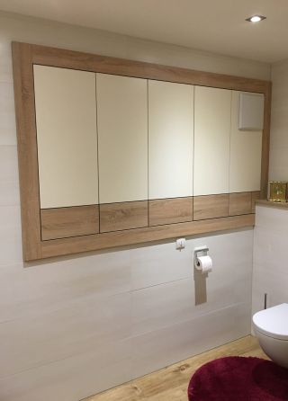Ein Badezimmer mit Blick auf einen bündigen Wandverbau mit Holzdekor