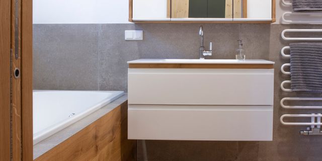 Ein Badezimmer in Eiche mit Blick auf einen Waschtisch und Spiegelschrank
